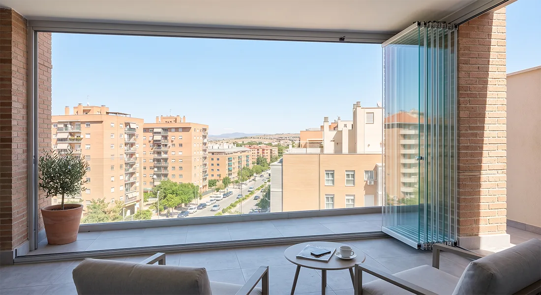 Cortina de cristal abierta con los paneles apilados en una terraza